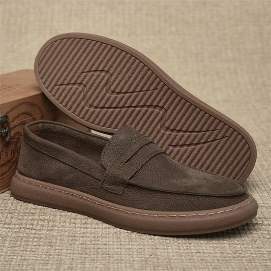 Brown loafers with a textured sole on a beige background